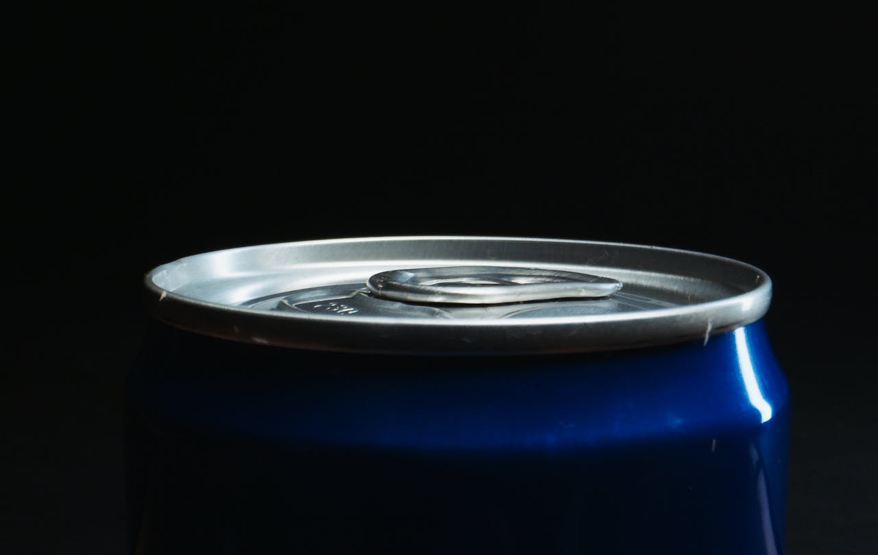 The Art of Drawing Readers In: Your attractive post title goes here Detailed view of a soda can's top contrasting with a black backdrop, highlighting the textures.